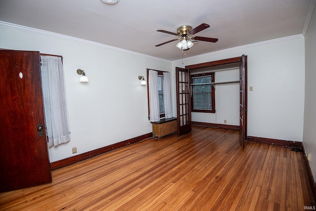 spare room featuring light wood-type flooring, ceiling fan, and crown molding