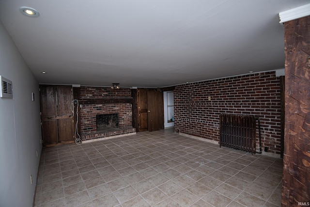 unfurnished living room featuring light tile patterned floors, brick wall, and a fireplace