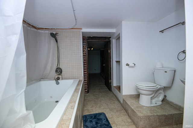 bathroom featuring tile patterned flooring, toilet, and tiled shower / bath