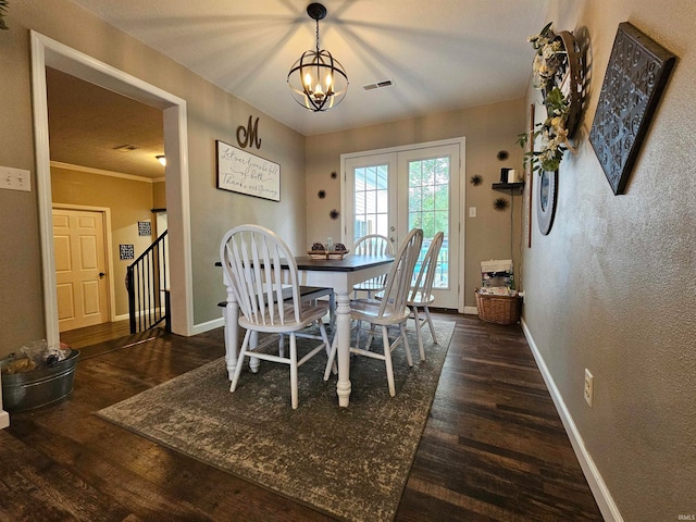 dining area with ornamental molding, dark hardwood / wood-style flooring, and a chandelier
