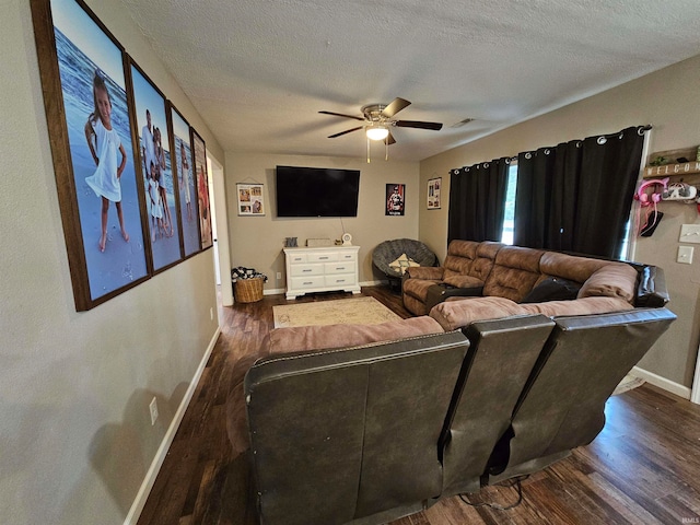 living room with ceiling fan, a textured ceiling, and dark hardwood / wood-style floors
