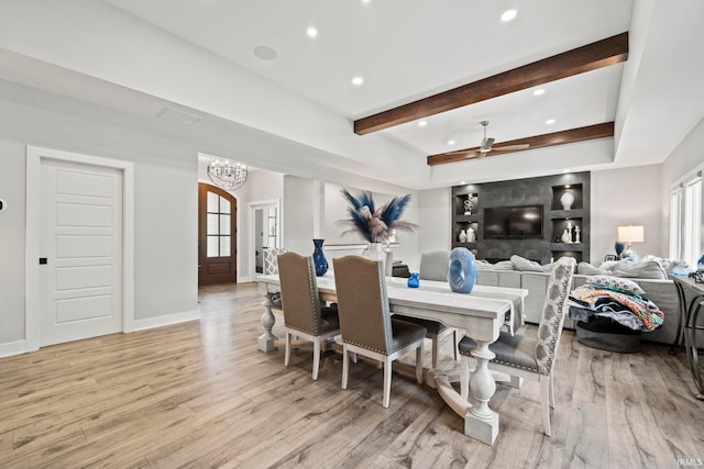 dining area with light wood-type flooring, ceiling fan with notable chandelier, and beam ceiling