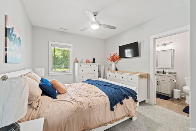 carpeted bedroom featuring connected bathroom and ceiling fan