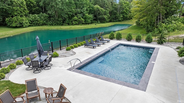 view of pool featuring a lawn, a patio, and a water view