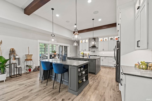 kitchen with a large island, light wood-type flooring, pendant lighting, gray cabinets, and white cabinetry