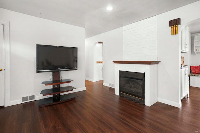 unfurnished living room with dark wood-type flooring