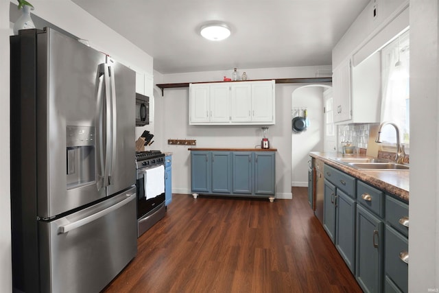 kitchen featuring white cabinets, sink, blue cabinetry, appliances with stainless steel finishes, and dark hardwood / wood-style flooring