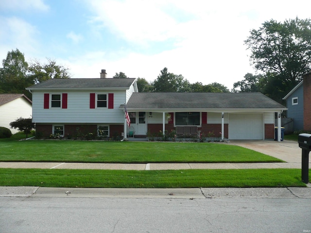 tri-level home with a porch, a garage, and a front lawn