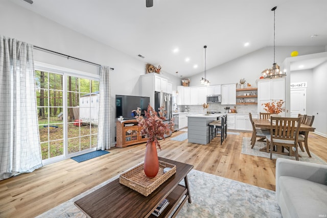 living room featuring an inviting chandelier, light wood-type flooring, and lofted ceiling