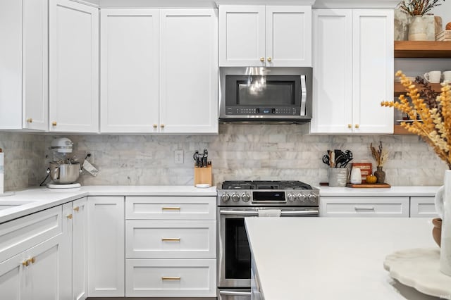 kitchen with appliances with stainless steel finishes, white cabinetry, and tasteful backsplash