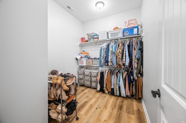 walk in closet with hardwood / wood-style floors