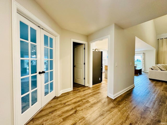 corridor featuring french doors and light hardwood / wood-style floors