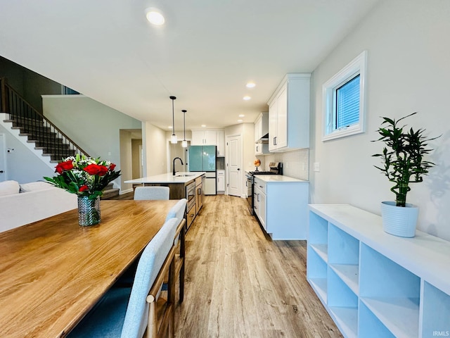 dining space with light wood-type flooring and sink