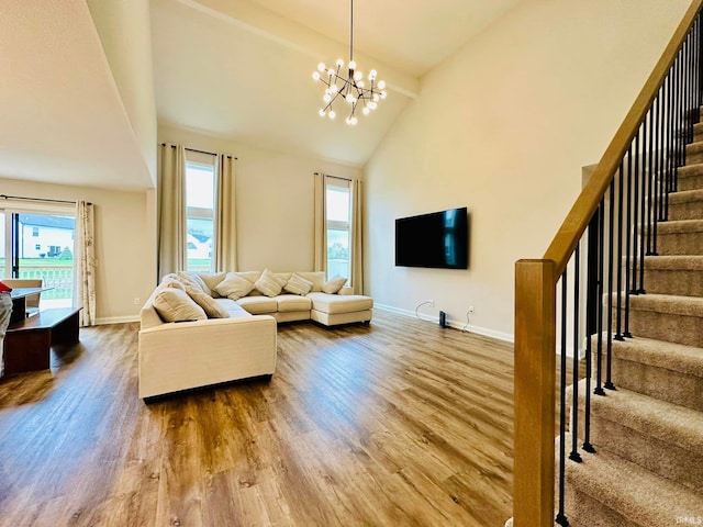 living room featuring wood-type flooring, a chandelier, and high vaulted ceiling