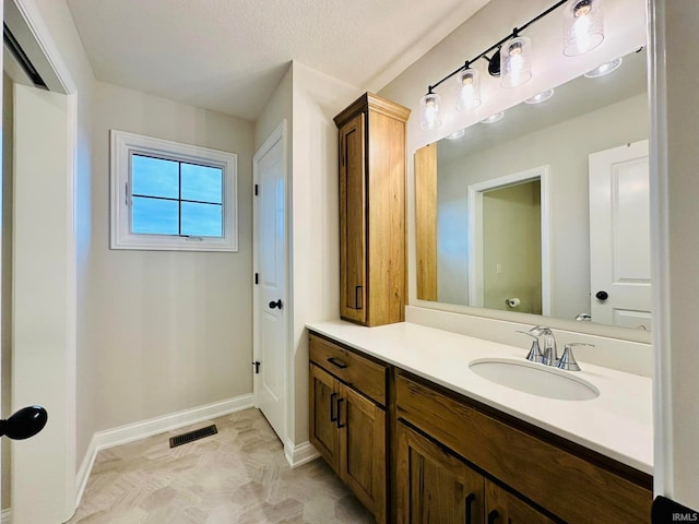 bathroom featuring a textured ceiling and vanity