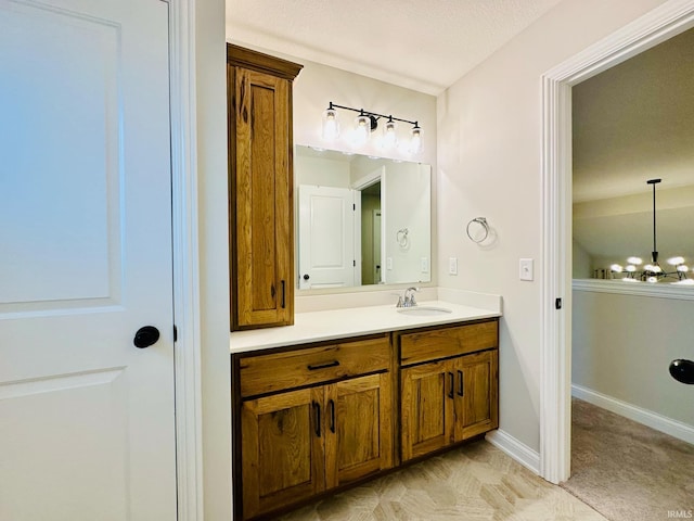 bathroom with vanity, a notable chandelier, and a textured ceiling