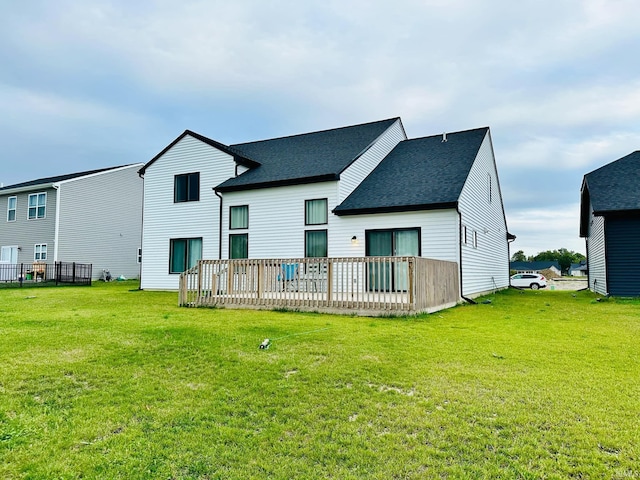 back of property with a deck and a yard