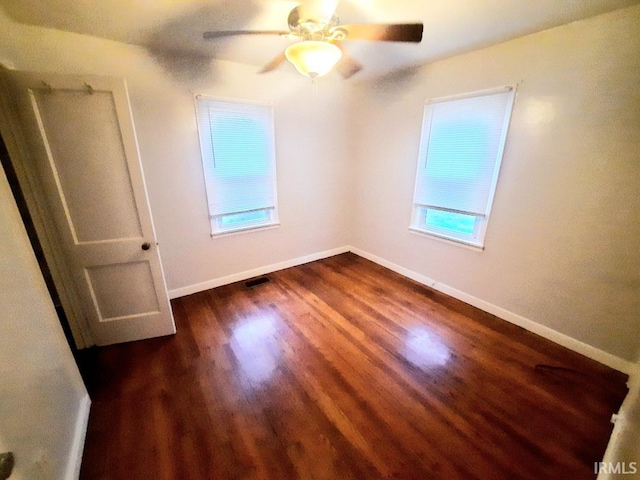 spare room with ceiling fan and dark wood-type flooring