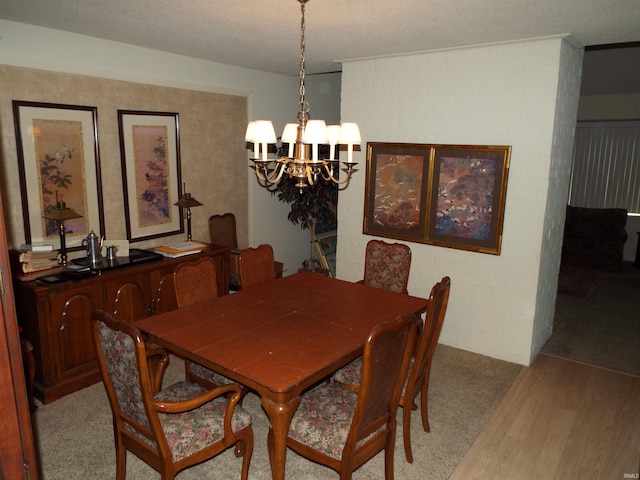 dining area featuring light colored carpet, an inviting chandelier, and a textured ceiling