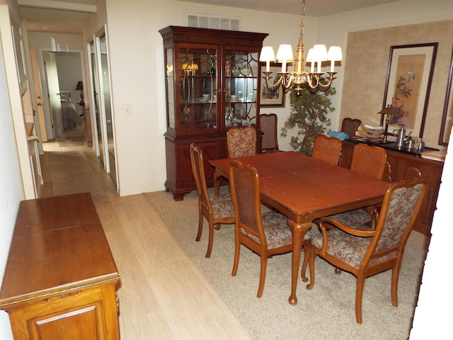 dining space featuring an inviting chandelier and light wood-type flooring