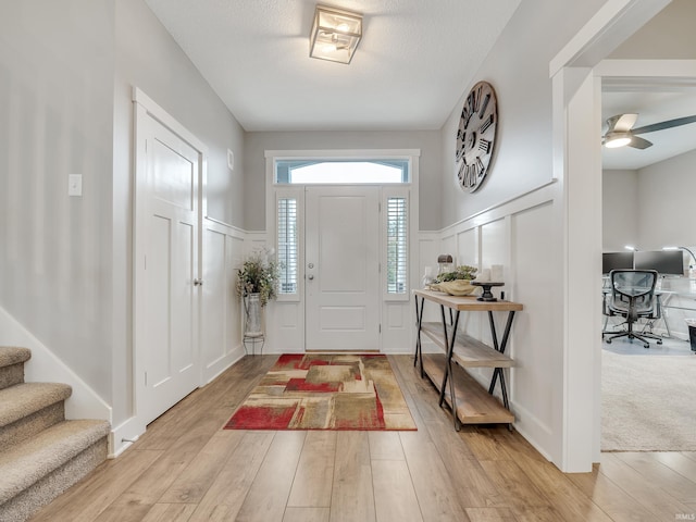 foyer entrance with light hardwood / wood-style flooring and ceiling fan