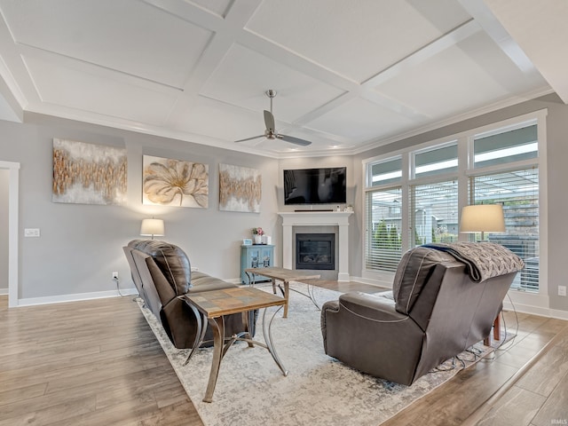 living room with coffered ceiling, light hardwood / wood-style flooring, ornamental molding, and ceiling fan