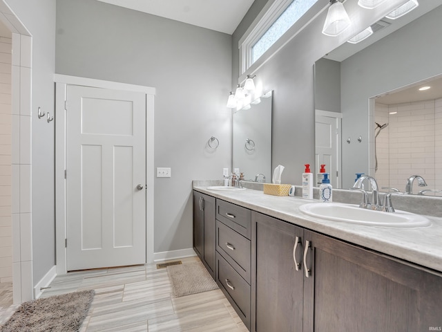 bathroom with a tile shower, hardwood / wood-style flooring, and vanity