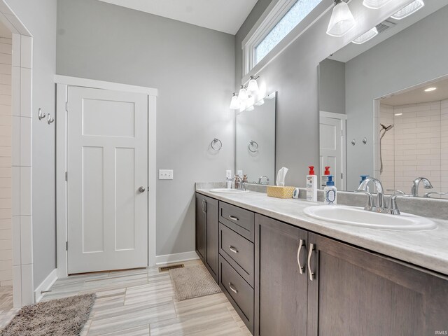 381 Elderwood Ct, Fort Wayne, IN 46845 - bathroom featuring a sink, visible vents, double vanity, and tiled shower