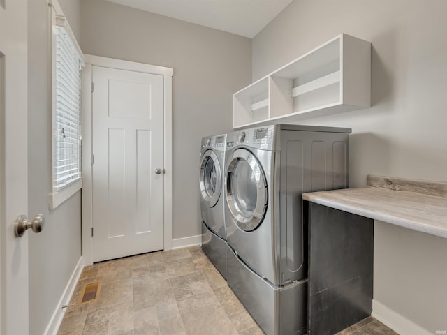 381 Elderwood Ct, Fort Wayne, IN 46845 - washroom with baseboards, visible vents, laundry area, stone finish flooring, and washing machine and clothes dryer