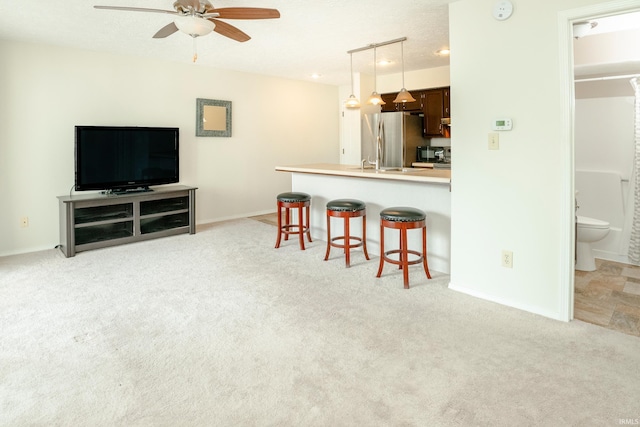 carpeted living room with ceiling fan