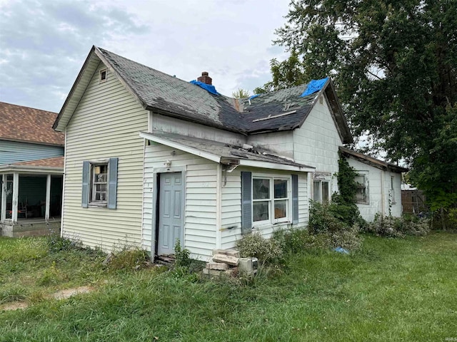 rear view of house featuring a lawn