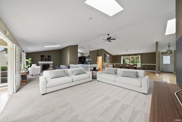 carpeted living room featuring vaulted ceiling and ceiling fan