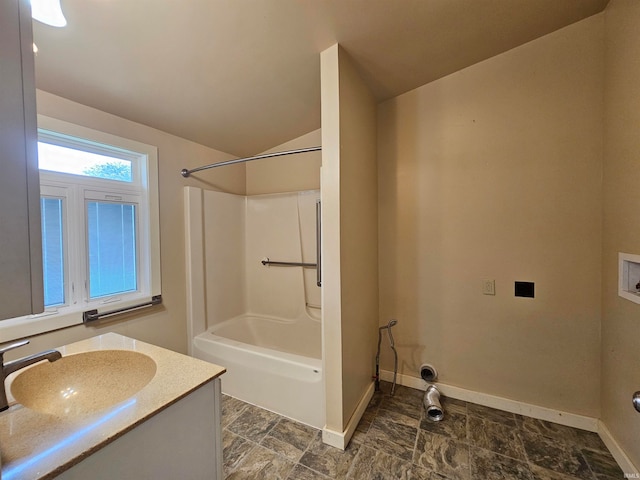 bathroom featuring vanity, vaulted ceiling, and shower / bath combination