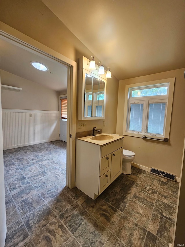 bathroom featuring vanity, vaulted ceiling, and toilet