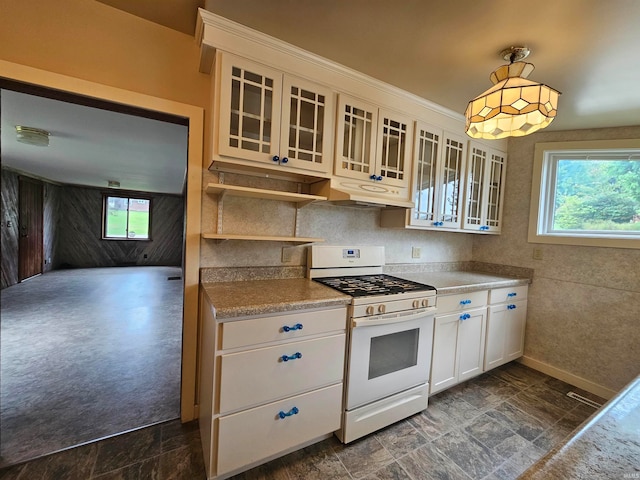 kitchen with white range with gas stovetop, hanging light fixtures, and white cabinets