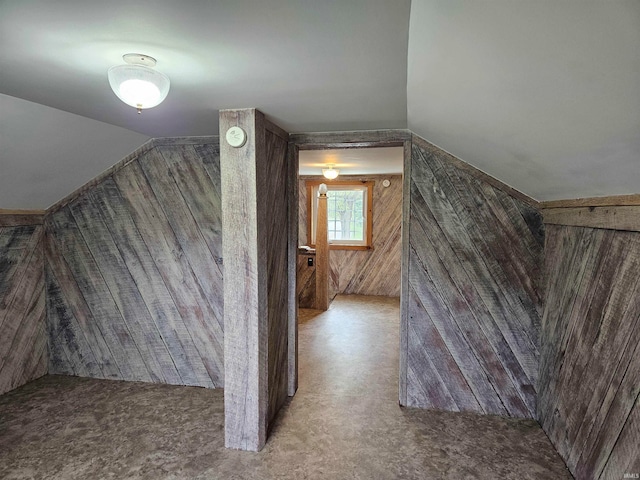 bonus room featuring wooden walls and vaulted ceiling