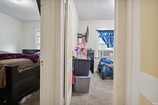 bedroom with cooling unit, a textured ceiling, and carpet flooring