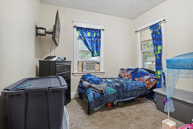 carpeted bedroom featuring cooling unit and a textured ceiling