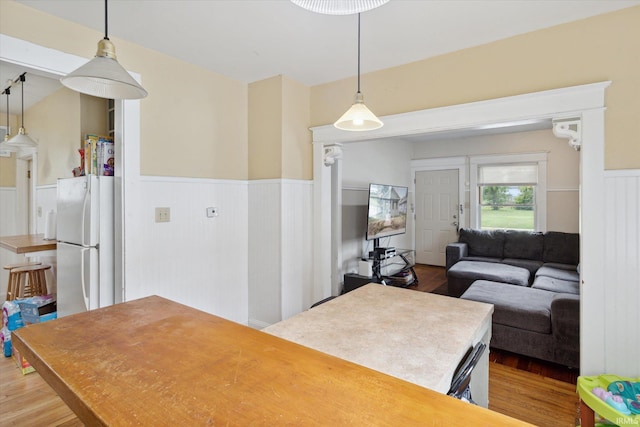 kitchen with pendant lighting, hardwood / wood-style flooring, and white fridge