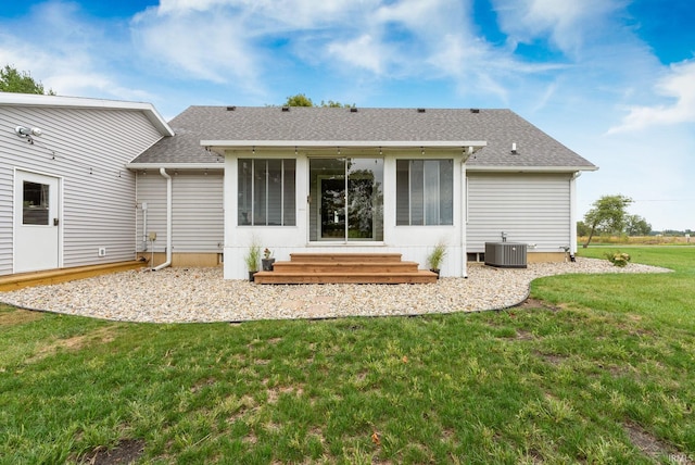 back of property with a lawn and central AC