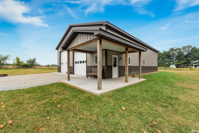 rear view of property featuring a lawn and a garage