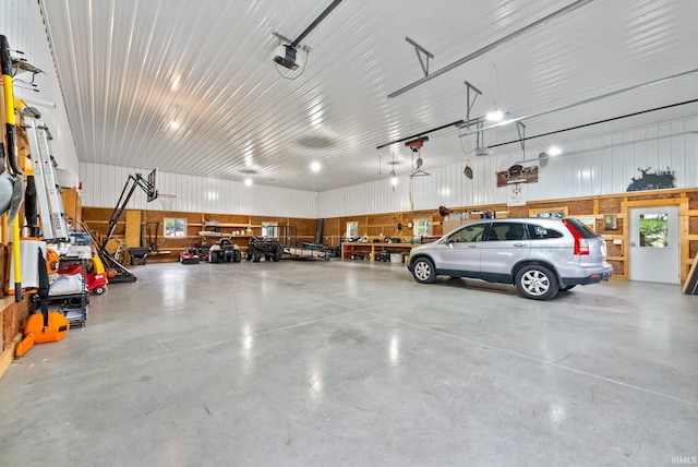 garage featuring a garage door opener and wood walls