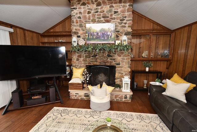 living room with a stone fireplace, lofted ceiling, wood walls, and dark wood-type flooring