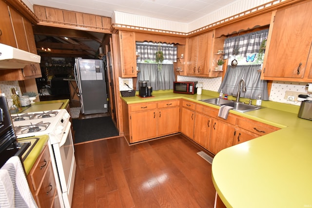 kitchen featuring sink, tasteful backsplash, dark wood-type flooring, stainless steel refrigerator, and white stove