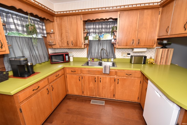 kitchen featuring dishwasher, dark wood-type flooring, sink, and tasteful backsplash