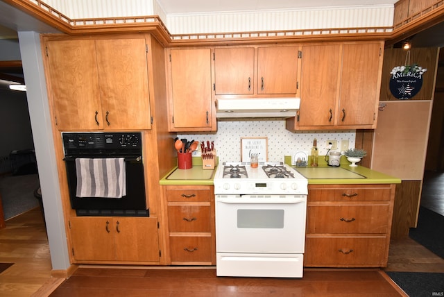 kitchen featuring dark hardwood / wood-style floors, oven, white gas range, and decorative backsplash