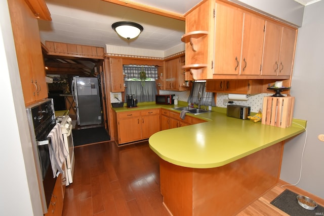 kitchen featuring black appliances, kitchen peninsula, dark wood-type flooring, and sink