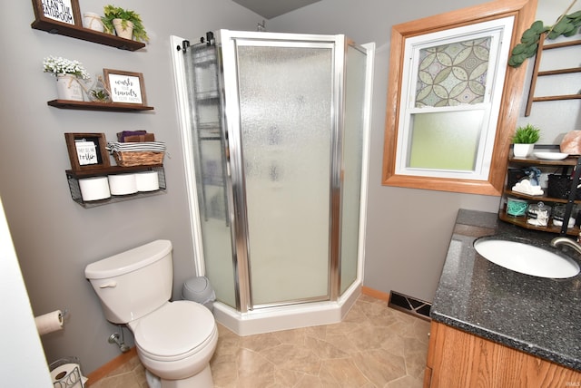 bathroom featuring walk in shower, vanity, and toilet