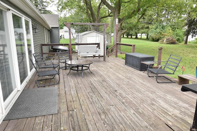 deck featuring a storage shed and a lawn