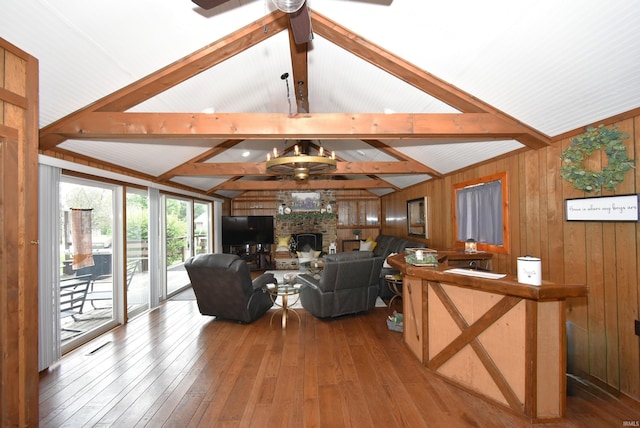 living room featuring hardwood / wood-style flooring, a fireplace, wood walls, and lofted ceiling with beams